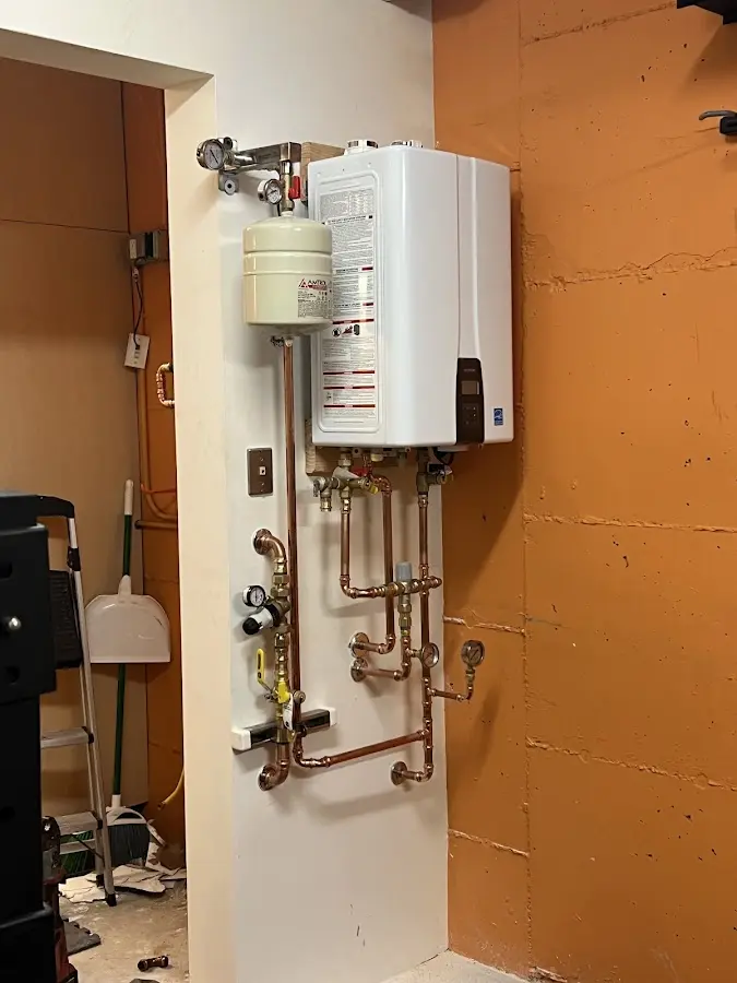 Plumbing technician inspecting water heater connections in West Hanover